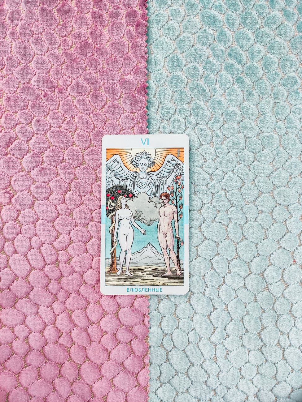 a tarot card om blue and pink surface